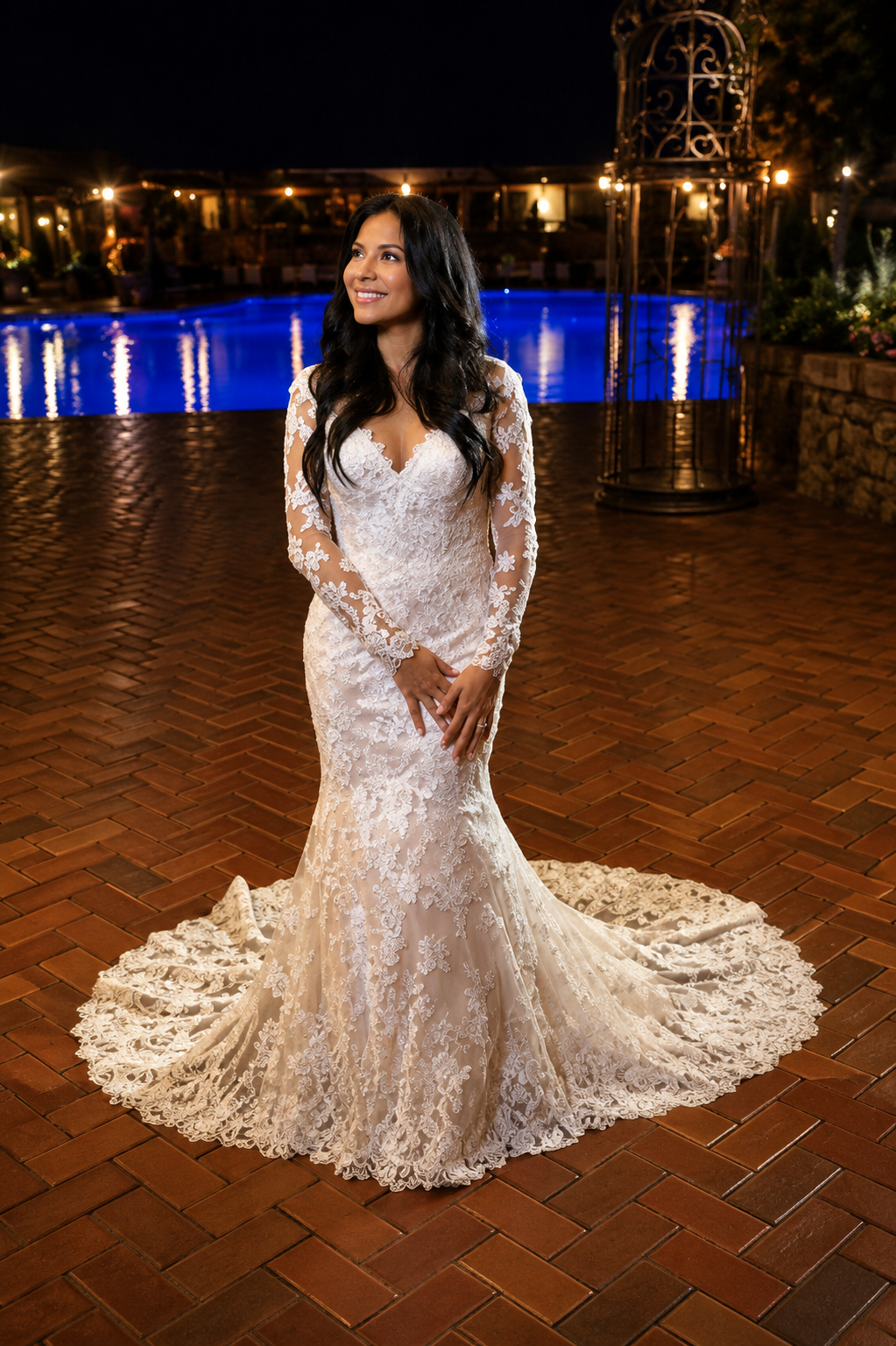 Long-sleeve lace mermaid gown by a pool at night