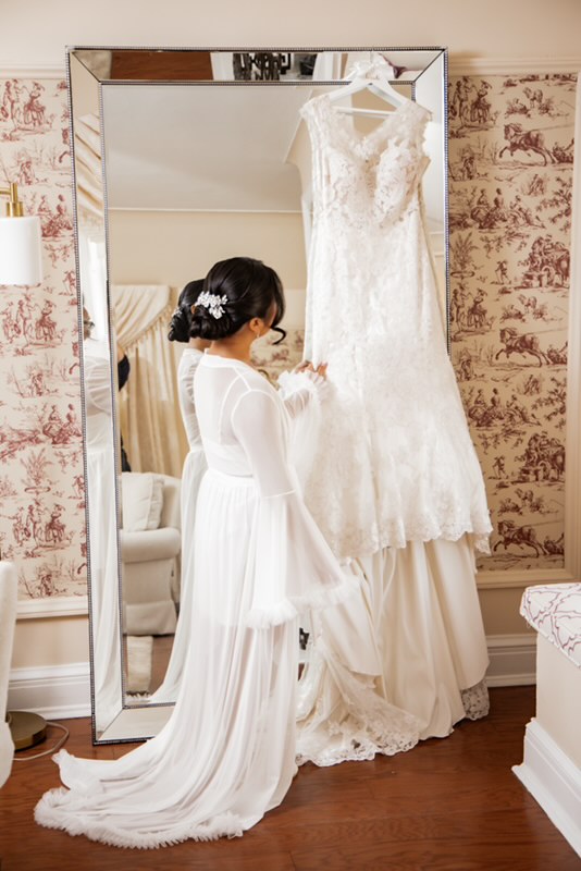 Bride admiring her lace gown before the ceremony